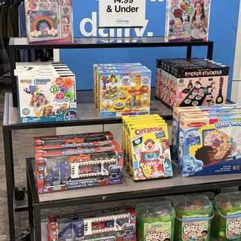 Macy's - Children's toys and craft kits, including slime, jewelry, and building sets, are arranged on a store shelf in a retail environment. - Department Stores Near Me - Albuquerque, New Mexico