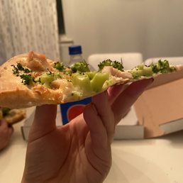 Side view White pizza with chicken and broccoli Side view White pizza with chicken and broccoli