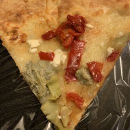 A double slice of pizza. Artichoke and roasted red peppers with mozzarella and feta cheese. A double slice of pizza. Artichoke and roasted red peppers with mozzarella and feta cheese.