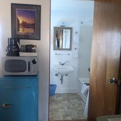 Looking toward the bathroom with mini fridge, microwave, and coffee maker to left of bathroom door.