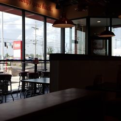 Freddy's Frozen Custard & Steakburgers - Front seating area with tables and booths.  The sign says occupancy 92.