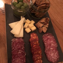 Charcuterie board with 2 types of cheese and 3 types of meat, figs, olives and crackers. Charcuterie board with 2 types of cheese and 3 types of meat, figs, olives and crackers.