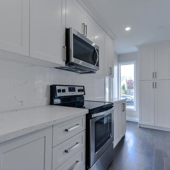 ProPoint Construction - a kitchen with white cabinets and stainless steel appliances - General Contractors Near Me ProPoint Construction - a kitchen with white cabinets and stainless steel appliances - General Contractors Near Me
