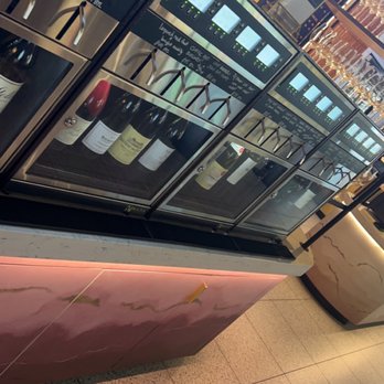 Vinotopia - a display of bottles of wine in a wine shop - Wine Bars Near Me - Plano, Texas