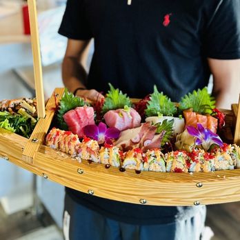 Kin Thai & Sushi - a man holding a tray of sushi - Thai Near Me - San Antonio, Texas Kin Thai & Sushi - a man holding a tray of sushi - Thai Near Me - San Antonio, Texas