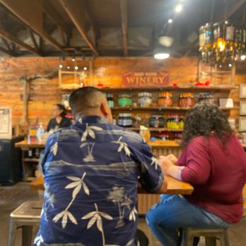 Noisy Water Winery - a man and a woman sitting at a bar - Cheese Shops Near Me - Ruidoso, New Mexico Noisy Water Winery - a man and a woman sitting at a bar - Cheese Shops Near Me - Ruidoso, New Mexico