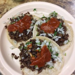 Tacos carne asada with everything and topped with hot sauce Tacos carne asada with everything and topped with hot sauce