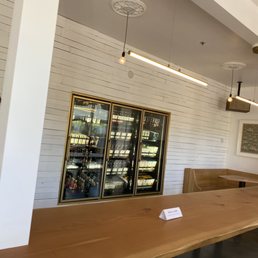 a long wooden table with a cooler in the back a long wooden table with a cooler in the back