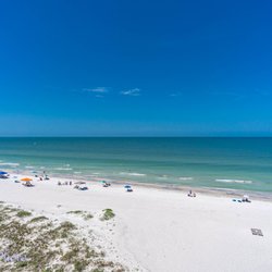 Chateau - Plumlee Gulf Beach Realty - A view the white sandy beach and turquoise waters of the Gulf of Mexico from a private balcony of a Chateaux condo.