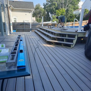 LB Construction - a deck with a table and chairs - Roofing Near Me