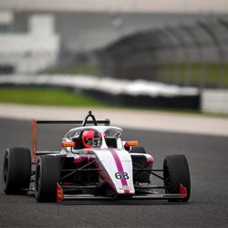 Allen Berg Racing Schools - Open-wheel formula car navigating a turn during high-performance race training.