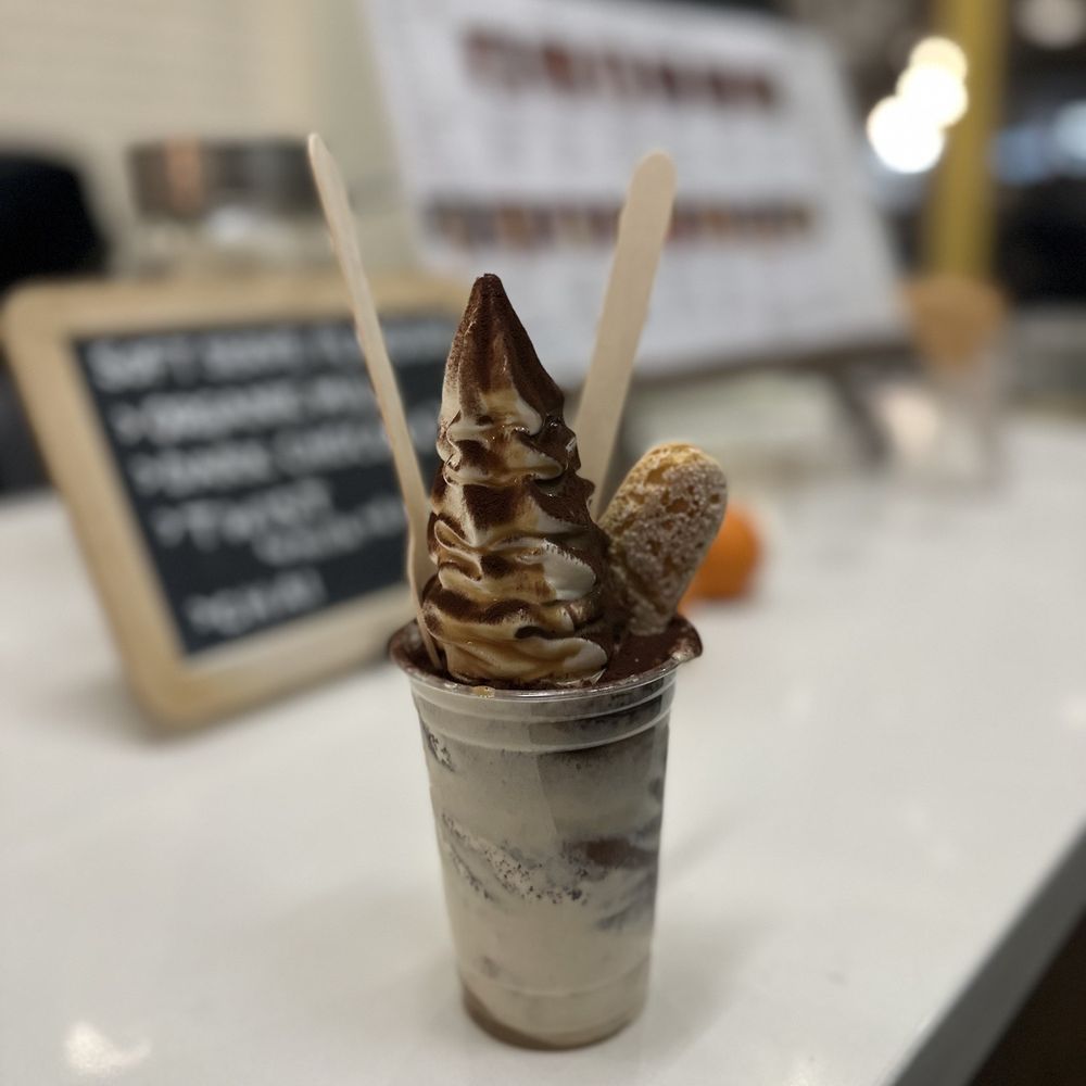a cup of ice cream with a spoon sticking out of it a cup of ice cream with a spoon sticking out of it