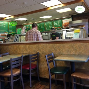 Subway - a man sitting at a counter in a restaurant - Sandwiches Near Me - Albert Lea, Minnesota