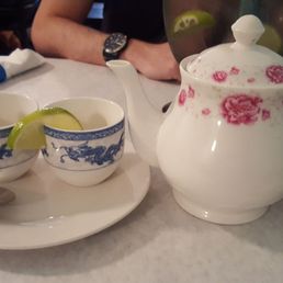 Jasmine tea in a pot w/ two small cups with little lime wedges Jasmine tea in a pot w/ two small cups with little lime wedges