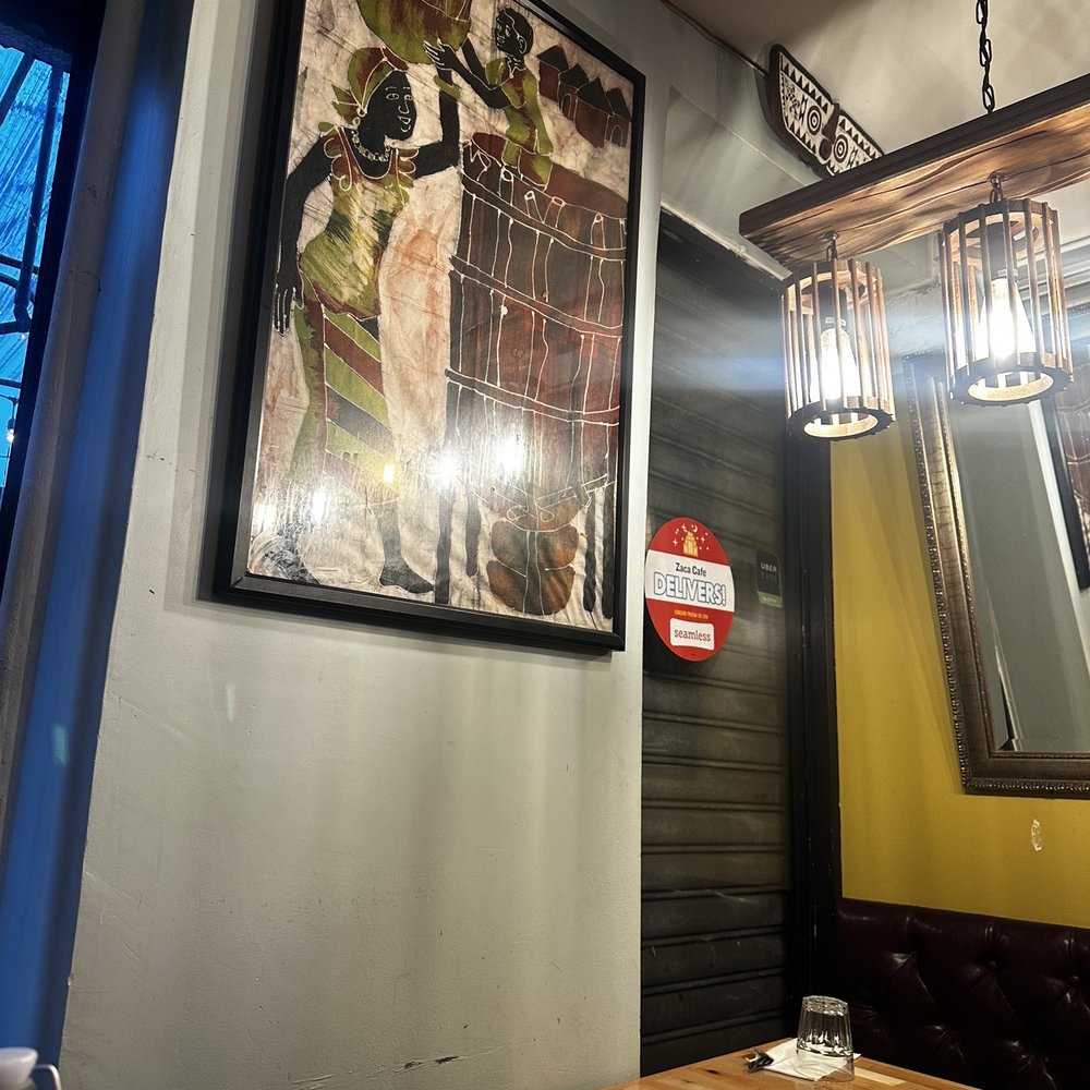 Zaca Cafe - a table and chairs with a framed picture on the wall - Coffee & Tea Near Me - Brooklyn, New York