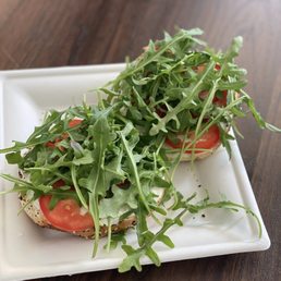 a sandwich with arugula and tomatoes a sandwich with arugula and tomatoes