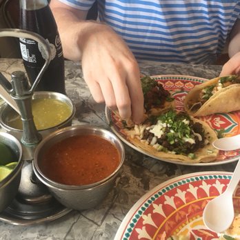 Casadores Taco - a man sitting at a table with plates of food - Mexican Near Me - Onarga, Illinois