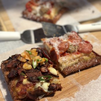 PI LA Pizza - two pieces of pizza on a cutting board - Pizza Near Me - Los Angeles, California PI LA Pizza - two pieces of pizza on a cutting board - Pizza Near Me - Los Angeles, California