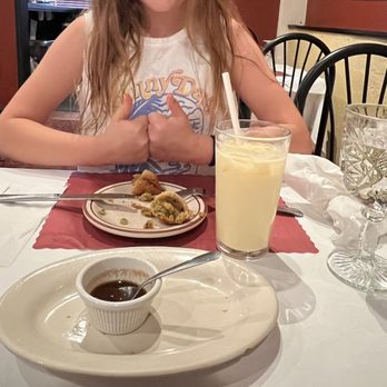 Bukharaa - a girl sitting at a table with a plate of food and a glass of milk - Indian Near Me - Suwanee, Georgia Bukharaa - a girl sitting at a table with a plate of food and a glass of milk - Indian Near Me - Suwanee, Georgia