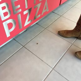 a person standing in front of a pizza box a person standing in front of a pizza box