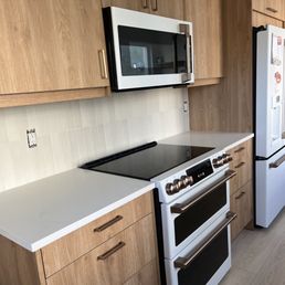 a kitchen with a stove, microwave, and refrigerator a kitchen with a stove, microwave, and refrigerator