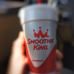 a hand holding a smoothie cup