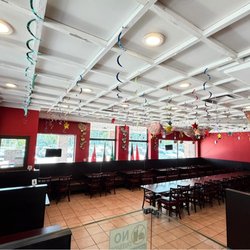 A bright and inviting dining space featuring ample seating, vibrant Pakistani-themed decorations, and a clean, family-friendl...