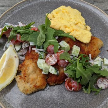 Trust - Turkey schnitzel with scrambled eggs and arugula salad with cherry tomatoes & cucumbers. - New American Near Me - San Diego, California Trust - Turkey schnitzel with scrambled eggs and arugula salad with cherry tomatoes & cucumbers. - New American Near Me - San Diego, California