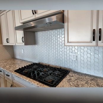 Mike's Tile and Backsplash - a kitchen with white cabinets and a stainless steel stove - Tiling Near Me Mike's Tile and Backsplash - a kitchen with white cabinets and a stainless steel stove - Tiling Near Me
