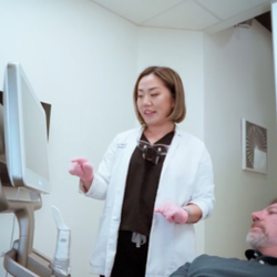 Ellem Dental: Lily Morgan, DDS - Dr. Lily Morgan talking with patent and reviewing digital screen.