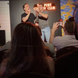 a man on a stage speaking to a group of people a man on a stage speaking to a group of people