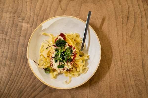 Photo of Barnwood - Niagara Falls, ON, CA. a plate of pasta with a fork on a wooden table