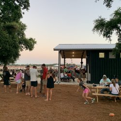 The Dock PCB - Back side of The Dock Bar with more tables and chair. Kids are playing on the lawn