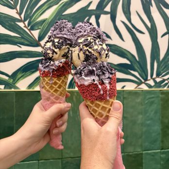 Sampaguita - Two dipped ice cream cones with two scoops: Ube Cheesecake & Bananoffee Pie topped with Ube sprinkles and Ube whipped cream. - Ice Cream & Frozen Yogurt Near Me - Orlando, Florida Sampaguita - Two dipped ice cream cones with two scoops: Ube Cheesecake & Bananoffee Pie topped with Ube sprinkles and Ube whipped cream. - Ice Cream & Frozen Yogurt Near Me - Orlando, Florida