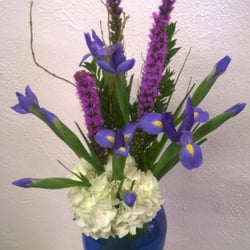 Ribbons & Roses - White hydrangea with blue iris and liatris in a blue vase.