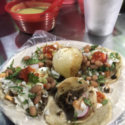 Taquería Cano's - Tacos with "everything" (cilantro, onions, cabbage), plus toppings (beans, avocado salsa, red salsa), and a grilled onion