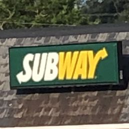 a subway sign on the roof of a building a subway sign on the roof of a building