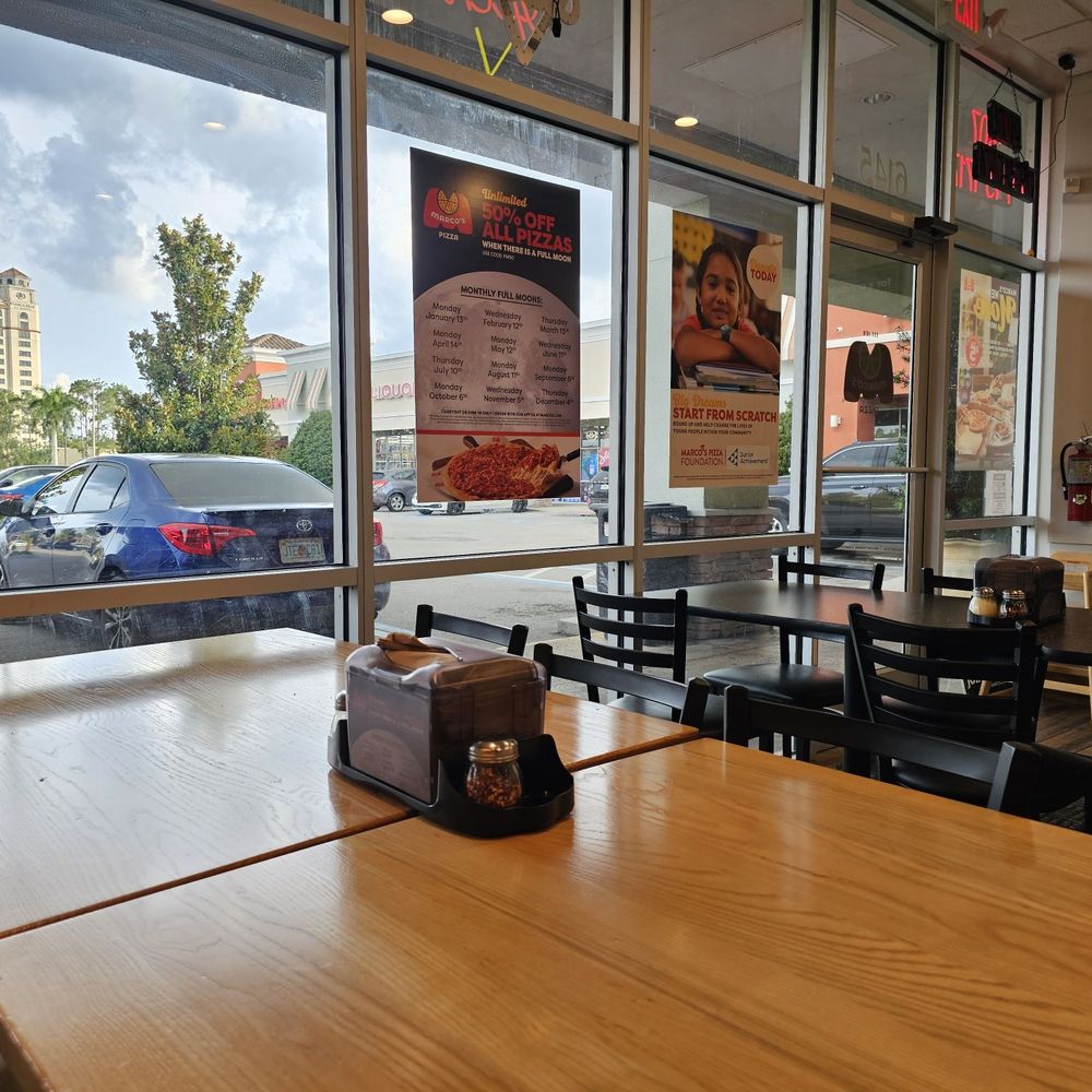 Marco's Pizza - Parking lot view, from furthest seat.  Have three tables/ 4 seats and two tables/2 seats total capacity - Chicken Wings Near Me - Orlando, Florida