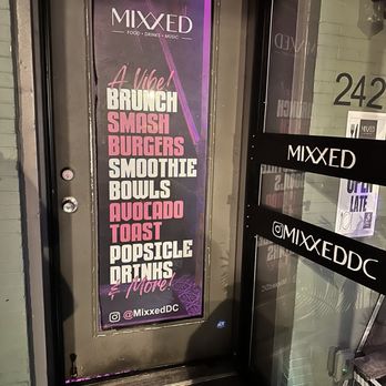 Mixxed DC - A vertical sign outside Mixxed Food And Drinks lists menu items like brunch, smash burgers, smoothies, and drinks, with social media info. - Burgers Near Me - Washington, DC, District of Columbia
