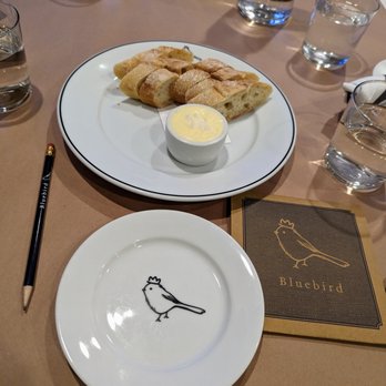 Bluebird - Inside. Table setting. Pencils are used to draw on the paper covering the table. Menu unfolds. Complimentary bread service. - French Near Me - Chapel Hill, North Carolina