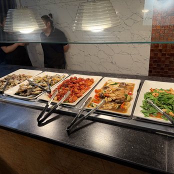 Royal Buffet - A buffet with various Asian cuisine dishes such as seafood, stir-fried vegetables, and cooked shellfish, arranged on white rectangular plates. - Buffets Near Me - Hoffman Estates, Illinois