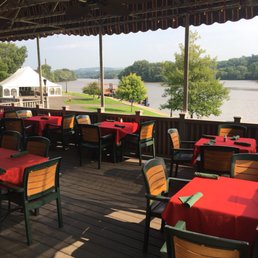 tables and chairs on a deck overlooking a river tables and chairs on a deck overlooking a river