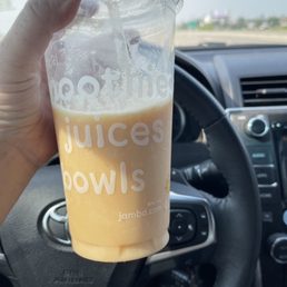 a hand holding a cup of juice a hand holding a cup of juice