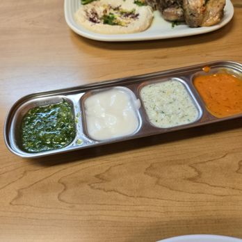 Jerusalem Restaurant - Sauces. Green fresh jalapeno taste, white is garlic mayo type (very mild), speckled is tzatziki and orange had a Buffalo vibe - Halal Near Me - Peoria, Illinois
