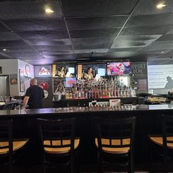Bogey's Bar and Grill - Bar. TV's. Bartender. Chairs. Bottles.