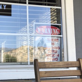 Old Isabella Coffee - Sign in front window saying "WARNING: THERE IS NOTHING HERE WORTH DYING OVER" with a gun pointed right at the reader. Disgusting. - Coffee & Tea Near Me - Lake Isabella, California