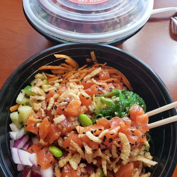 PokePro - Look at dem rainbow colors in my salmon bowl ! - A poke bowl filled with diced salmon, shredded carrots, cucumbers, onions, edamame, and seaweed salad, served in a black container with chopsticks, from Hawaii Tuna. - Poke Near Me - Norwalk, Connecticut