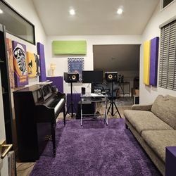 Acoustic panels hung above piano and behind speakers.