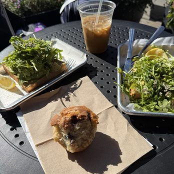 Think Coffee  - Avocado toast and half eaten blueberry muffin with streusel. Vanilla latte with almond milk. - Coffee & Tea Near Me - New York, New York