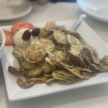 Santorini Greek Restaurant - a plate of potato chips and a bowl of salad - Greek Near Me - Merrick, New York Santorini Greek Restaurant - a plate of potato chips and a bowl of salad - Greek Near Me - Merrick, New York